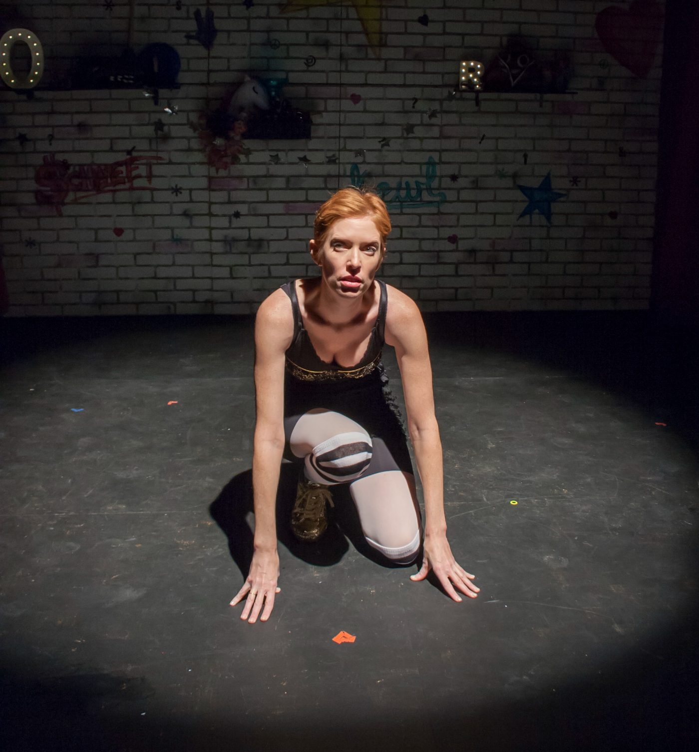 Adria Dawn crouching in a spotlight in Dorkumentary Live!