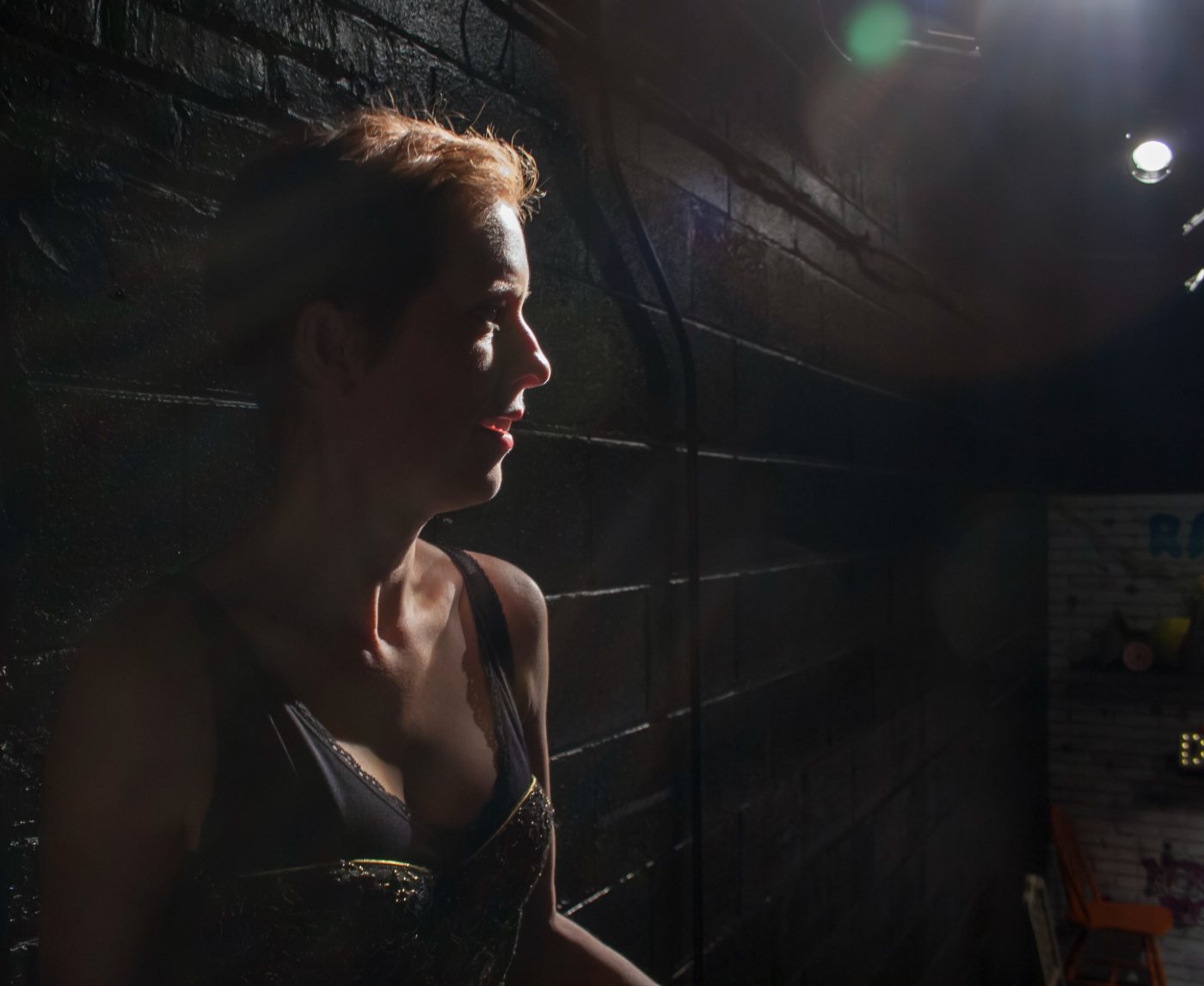 Adria Dawn in profile, rim-lit, in Dorkumentary Live!