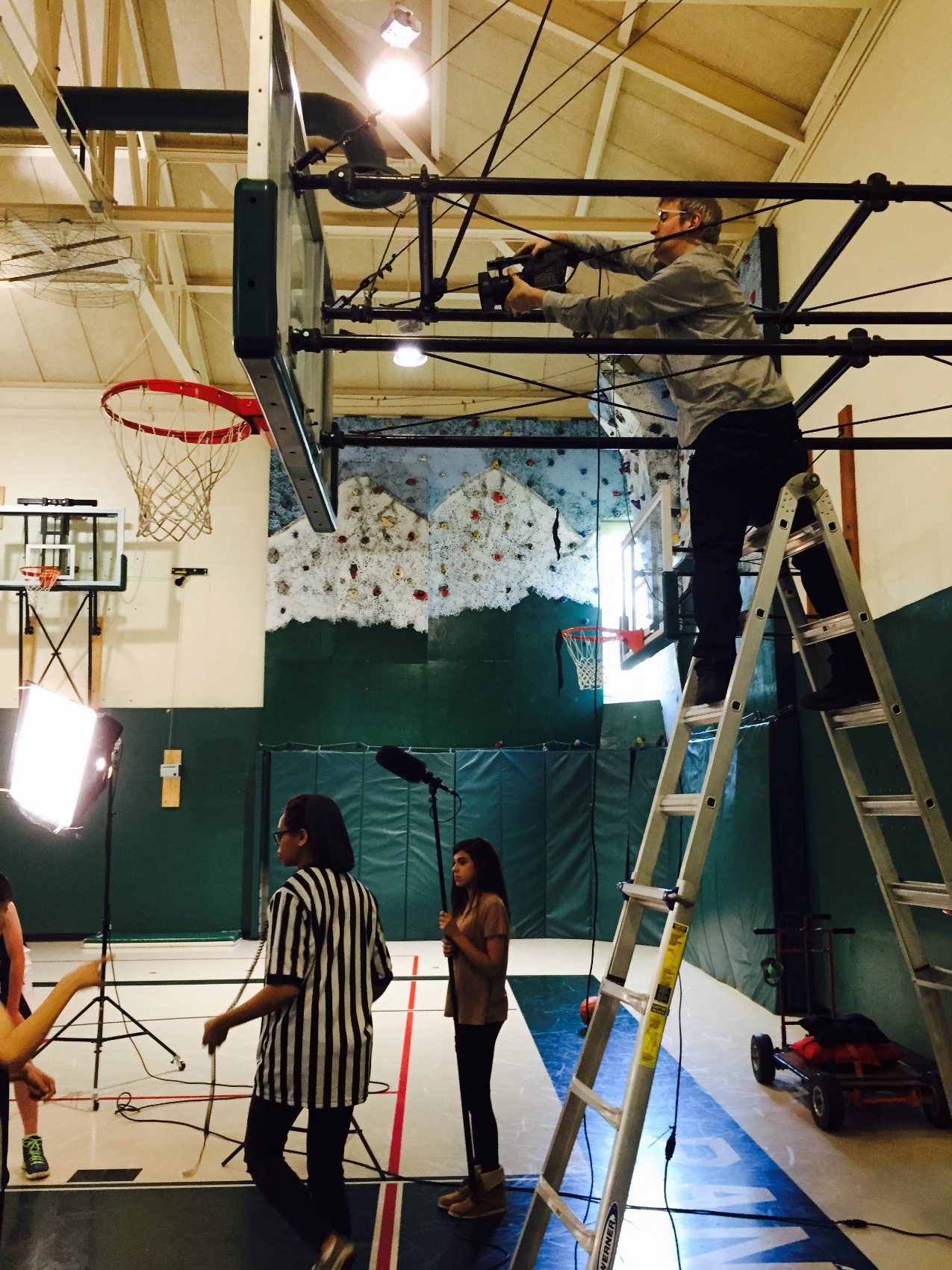 David Tarleton rigging a camera over a gym with student crew on a Kids Matter shoot